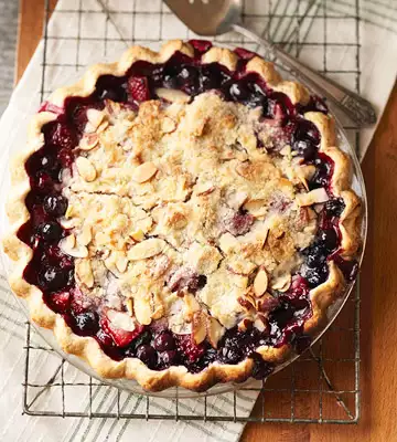 Freshly baked cherry pie made with bush cherries, topped with a golden crumble.