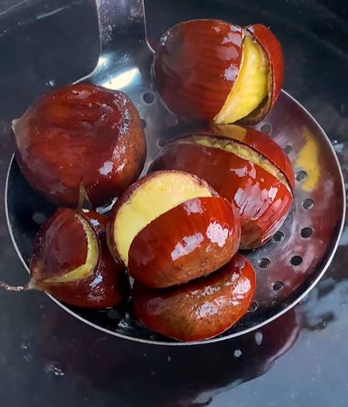 Chestnuts simmering in a pot of boiling water on the stovetop