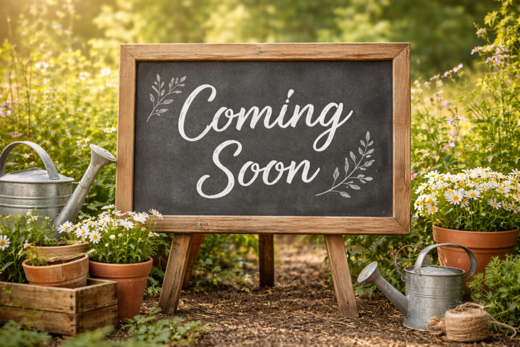 Rustic chalkboard sign reading “Coming Soon” in a garden setting, indicating farm hours are not yet available.