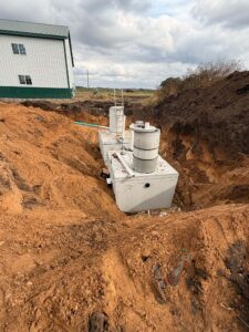 Concrete septic tanks installed in an excavation beside the Nuts About Dee's Berries farm building in Brodhead, Wisconsin.