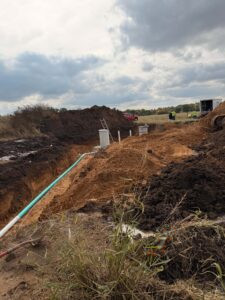 Underground septic pipe running through an excavated trench from the farm building toward the holding tank at Nuts About Dee's Berries in Brodhead, Wisconsin.